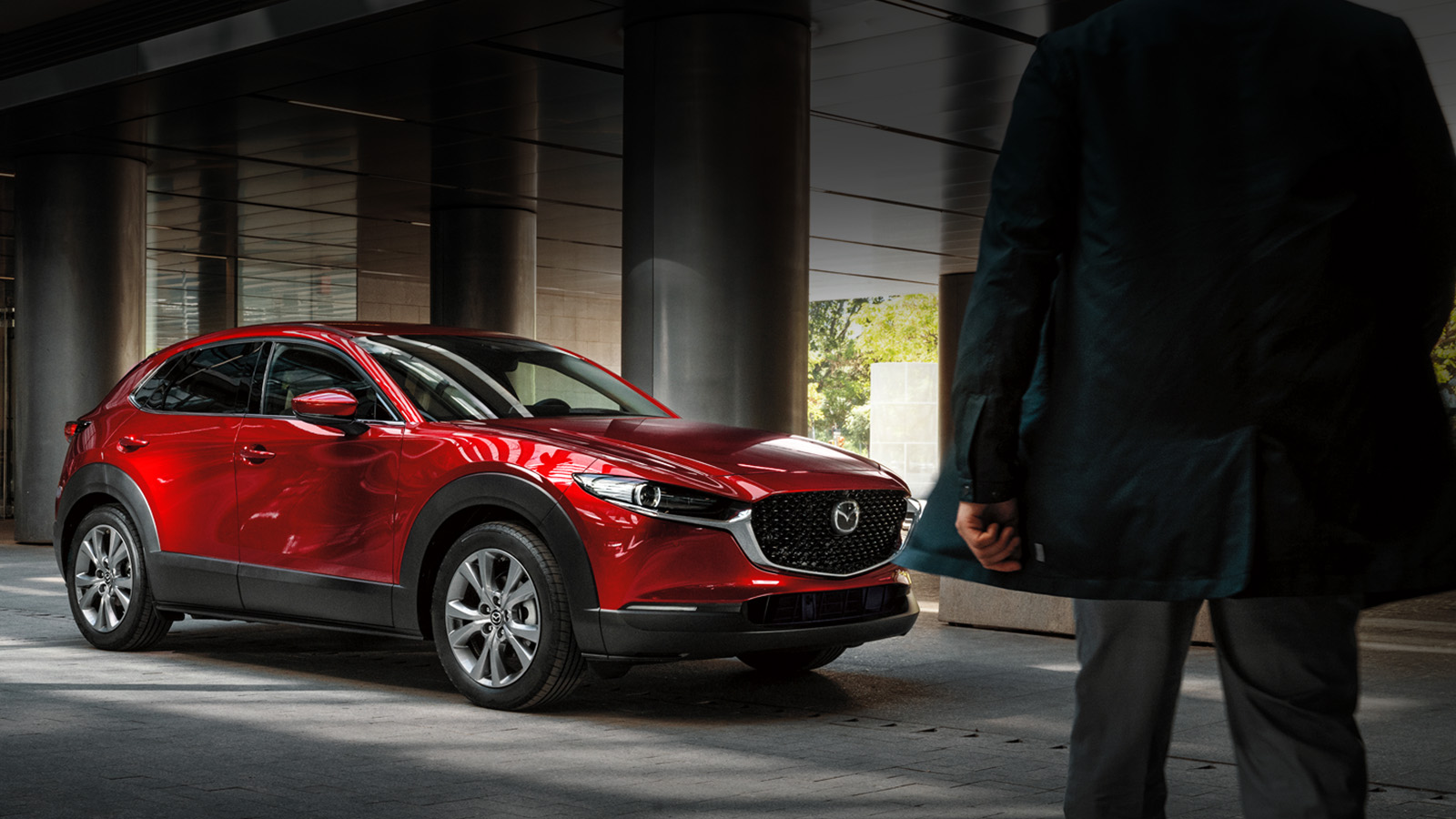 Une Mazda CX-30 rouge garée chez un concessionnaire.