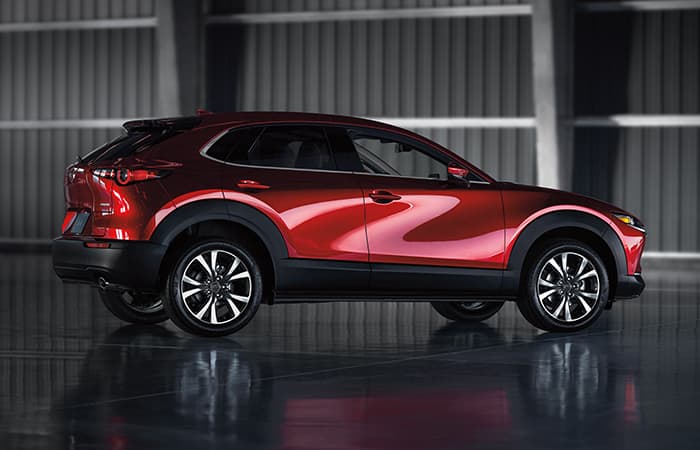 A red Mazda vehicle parked in a cargo bay.