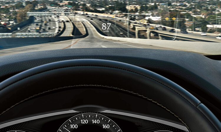 Driver’s view, 87 km/h is projected onto the CX-90’s interior windshield.